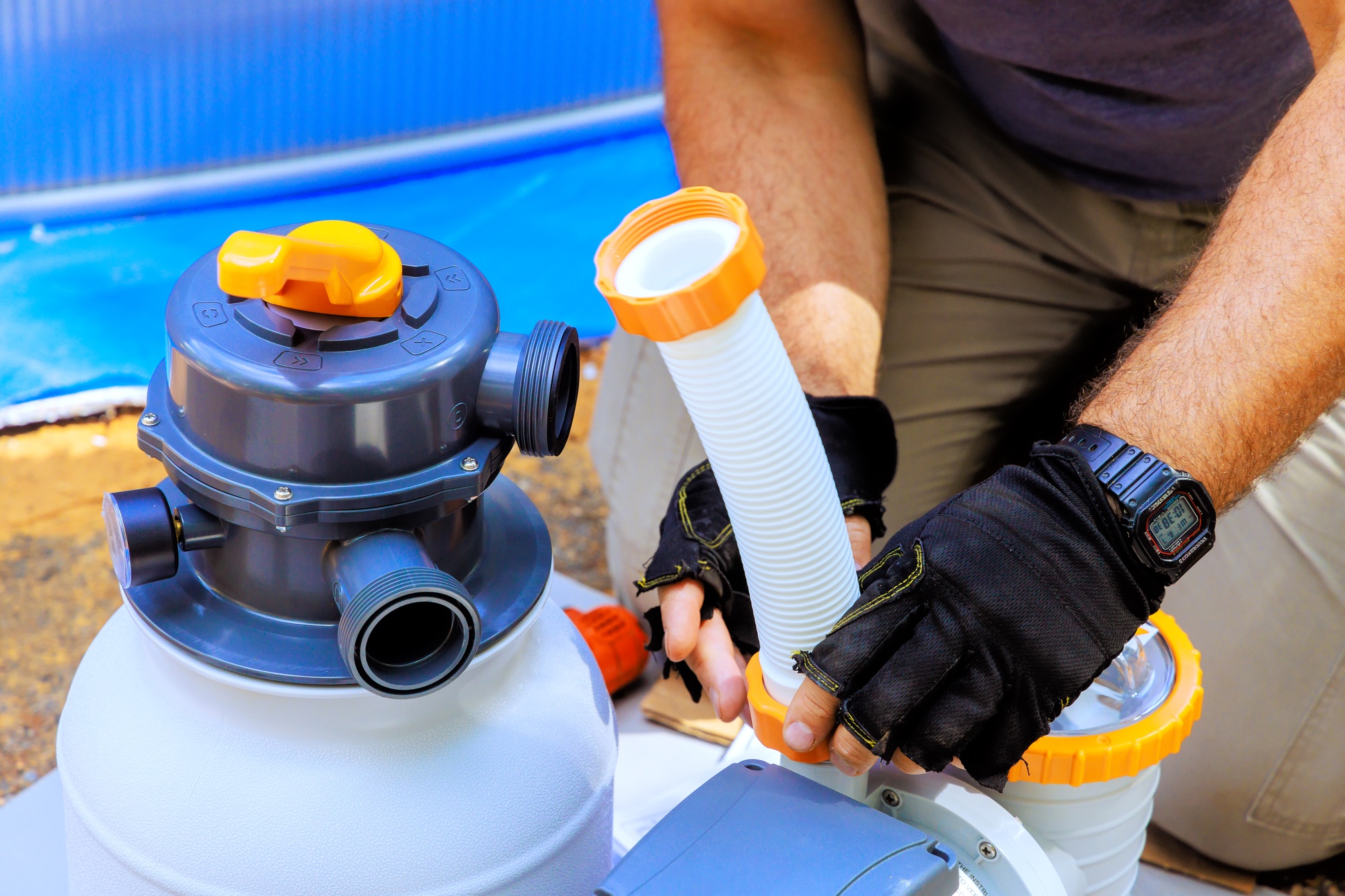 Maintenance worker assembles a sand filter system tank well as cleaning equipment for swimming pools